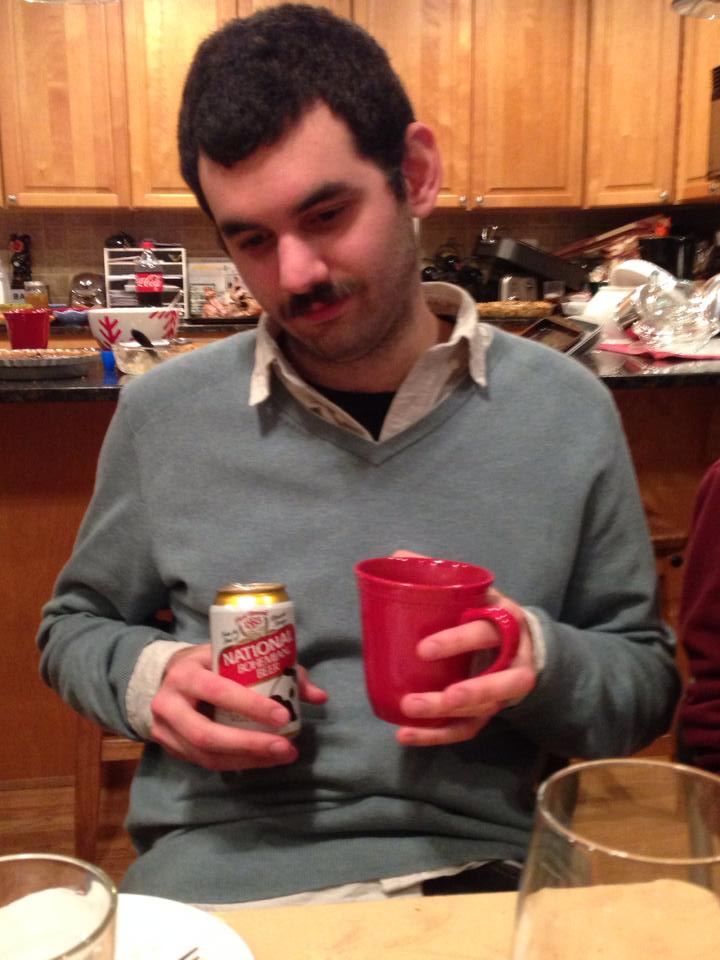 Photo of Larry Michaels double-fisting a natty boh & a mug of coffee