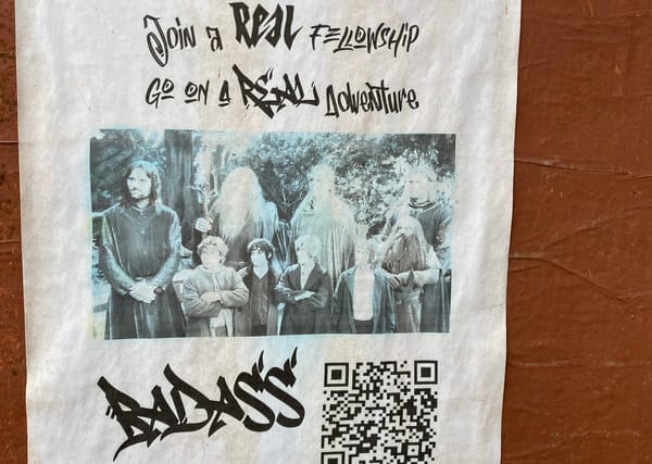 Flyer says "join a REAL fellowship, go on a REAL adventure", pic of LOTR fellowship, a faux graffiti "Badass" and a QR Code